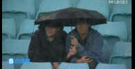 冒雨支持!国足比赛当地时间17点开球,球迷现场观战撑伞看球
